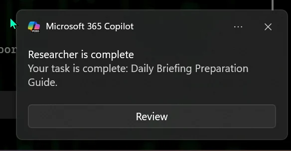 Screenshot from a Microsoft 365 Copilot tenant: a Windows notification from Microsoft 365 Copilot reading 'Researcher is complete — Your task is complete: Daily Briefing Preparation Guide' with a Review button.