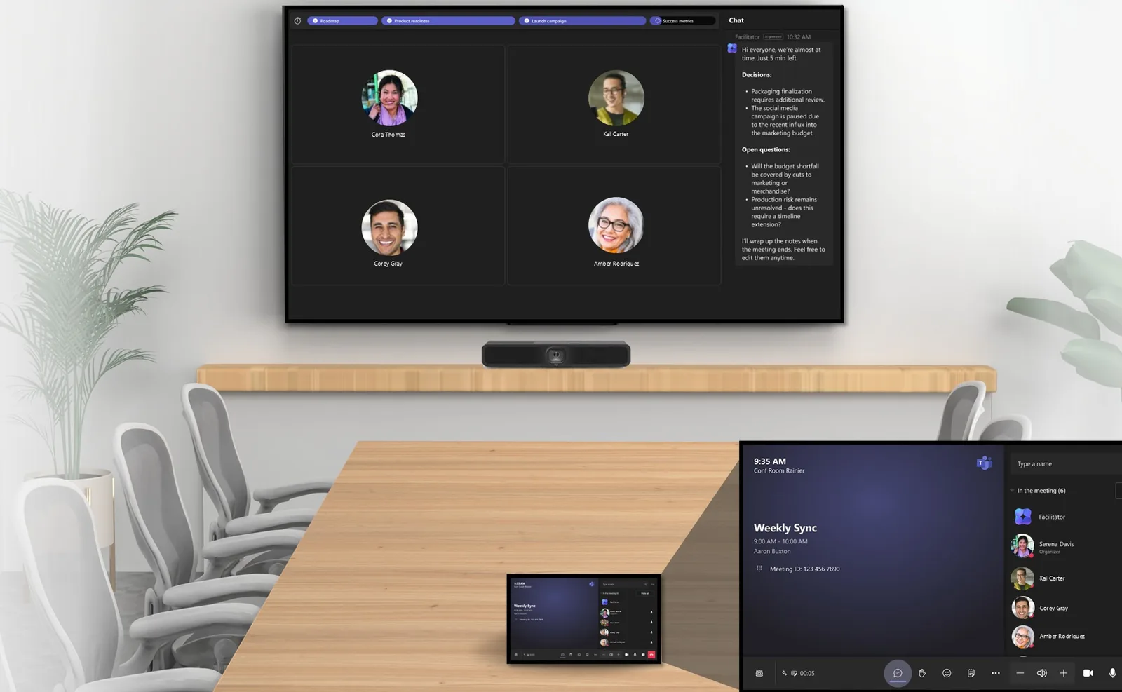A physical Teams Room with a wall-mounted display showing the Teams meeting and the Facilitator chat panel with decisions and open questions, plus a Teams Rooms console on the table showing the meeting details and a participant list that includes Facilitator.