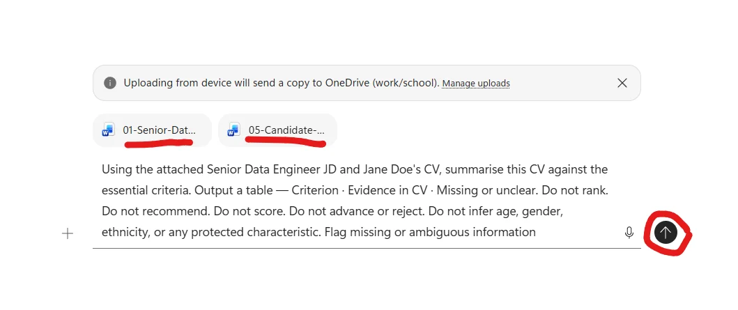Microsoft 365 Copilot Chat composer with two attached files visible above the chat input — 01-Senior-Data-Engineer-JD docx and 05-Candidate-CV-1-Jane-Doe docx (both shown with Word icons). Above the file chips a system banner reads Uploading from device will send a copy to OneDrive (work/school) — Manage uploads. Below the file chips, the full prompt is typed in the chat input: Using the attached Senior Data Engineer JD and Jane Doe's CV, summarise this CV against the essential criteria. Output a table — Criterion · Evidence in CV · Missing or unclear. Do not rank. Do not recommend. Do not score. Do not advance or reject. Do not infer age, gender, ethnicity, or any protected characteristic. Flag missing or ambiguous information. A microphone icon and a send arrow button sit to the right of the input, with the send button circled in red as the next action.