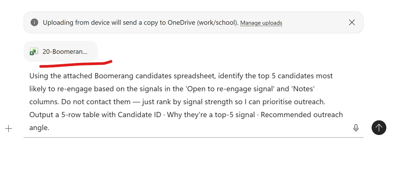 Microsoft 365 Copilot Chat composer with the file 20-Boomeran attached as an Excel file chip, underlined in red as an annotation. A system banner above reads Uploading from device will send a copy to OneDrive (work/school). Below the file chip the prompt is fully typed: Using the attached Boomerang candidates spreadsheet, identify the top 5 candidates most likely to re-engage based on the signals in the Open to re-engage signal and Notes columns. Do not contact them — just rank by signal strength so I can prioritise outreach. Output a 5-row table with Candidate ID · Why they're a top-5 signal · Recommended outreach angle. A plus upload button on the left, microphone and send arrow on the right.