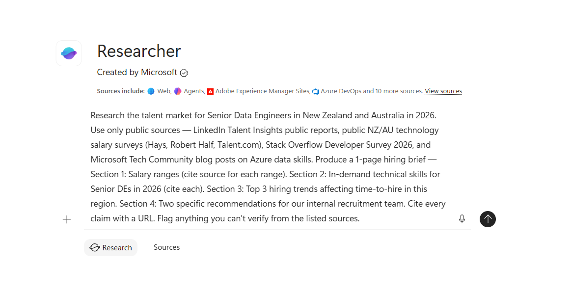 Microsoft 365 Copilot Researcher agent card. Purple-blue Researcher icon on the left. Title Researcher in large text. Created by Microsoft with a verified-tick badge. A Sources include row listing four icons with labels — Web (globe), Agents (purple sparkle), Adobe Experience Manager Sites (red A), Azure DevOps (cloud) — followed by the text and 10 more sources with a View sources link. Below the header card sits the prompt composer with the full talent-market research brief typed in: Research the talent market for Senior Data Engineers in New Zealand and Australia in 2026. Use only public sources — LinkedIn Talent Insights public reports, public NZ/AU technology salary surveys (Hays, Robert Half, Talent.com), Stack Overflow Developer Survey 2026, and Microsoft Tech Community blog posts on Azure data skills. Produce a 1-page hiring brief — Section 1: Salary ranges (cite source for each range). Section 2: In-demand technical skills for Senior DEs in 2026 (cite each). Section 3: Top 3 hiring trends affecting time-to-hire in this region. Section 4: Two specific recommendations for our internal recruitment team. Cite every claim with a URL. Flag anything you can't verify from the listed sources. A plus button on the left of the composer, a microphone icon on the right, and a circular Up-arrow send button to the far right. Below the composer two tabs labelled Research (selected, pill-style) and Sources.